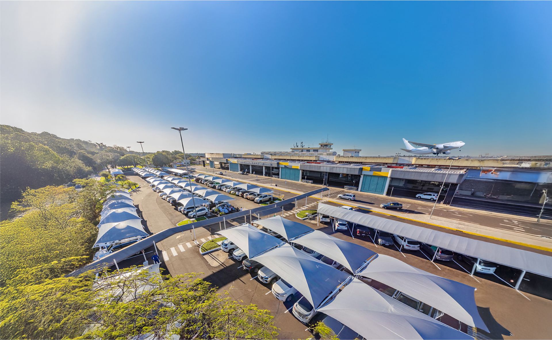 Vista panorâmica do estacionamento Tarobá no Aeroporto de Foz do Iguaçu com veículos estacionados e segurança